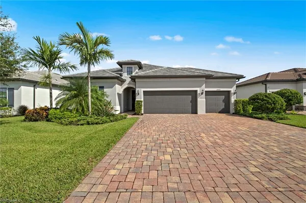 a front view of house with a yard and palm trees