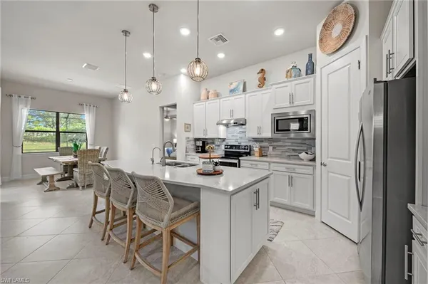 a kitchen with cabinets and chairs