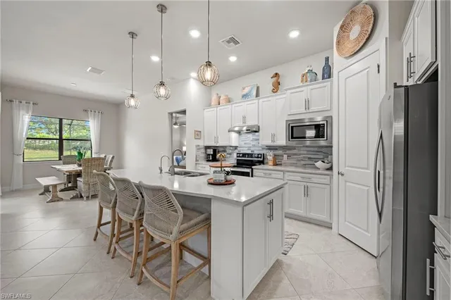 a kitchen with cabinets and chairs