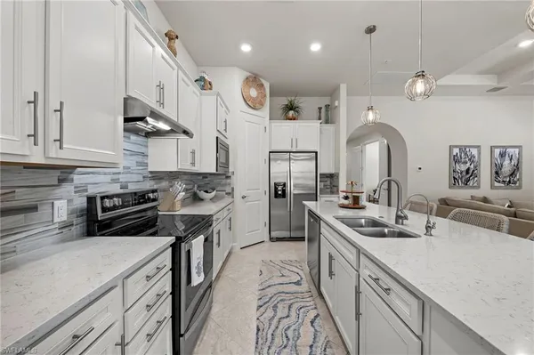 a kitchen with stainless steel appliances granite countertop a sink a stove and a refrigerator