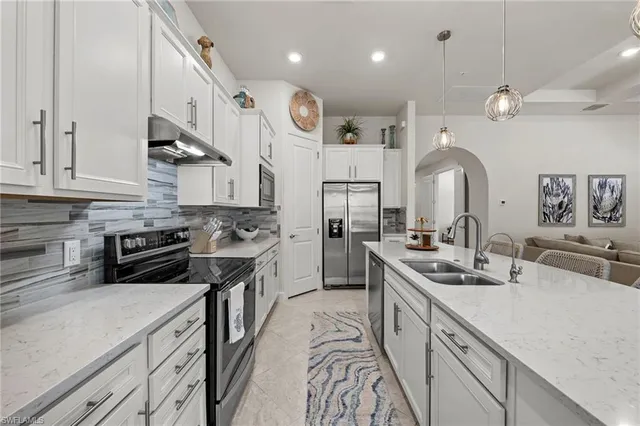 a kitchen with stainless steel appliances granite countertop a sink a stove and a refrigerator