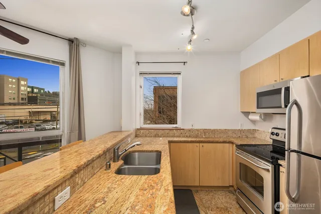 a bathroom with a granite countertop sink and a large mirror
