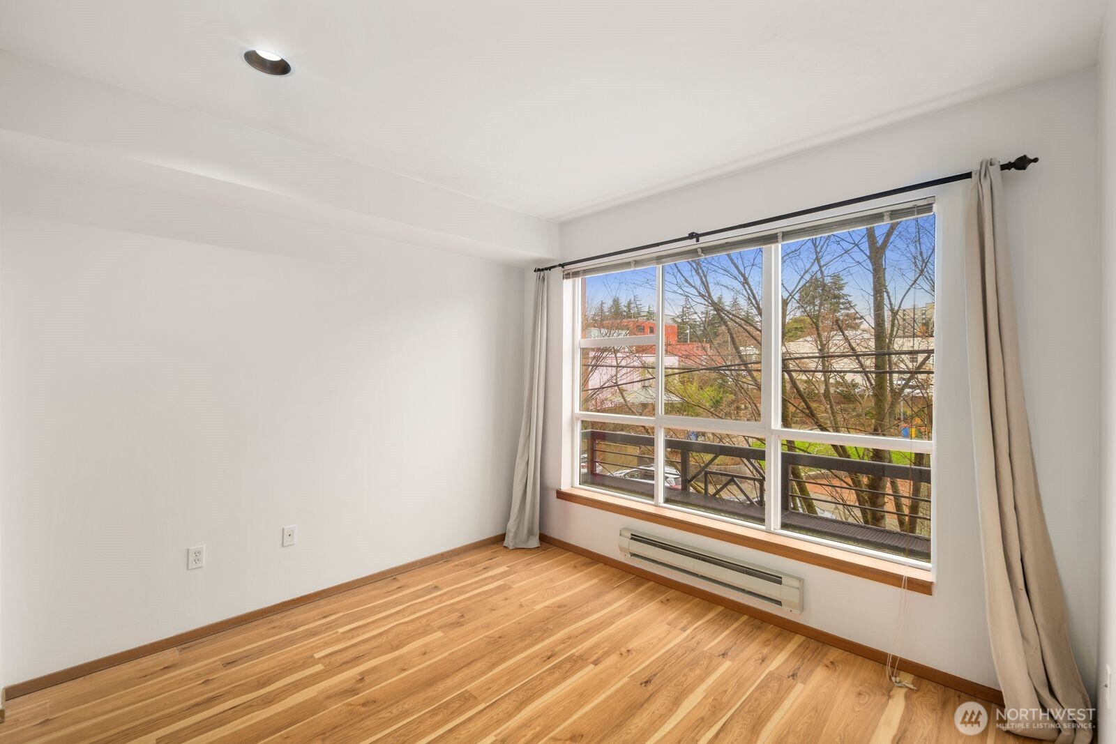 668 South Lane Street, Unit 314 Seattle, WA 98104 - Photo 19 of 36 a view of an empty room with wooden floor and a window