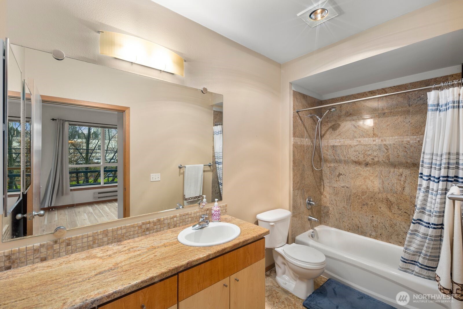 668 South Lane Street, Unit 314 Seattle, WA 98104 - Photo 21 of 36 a bathroom with a granite countertop sink toilet mirror and shower
