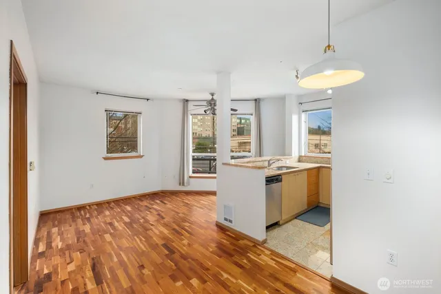 a view of a kitchen with stainless steel appliances granite countertop a stove and a wooden floors