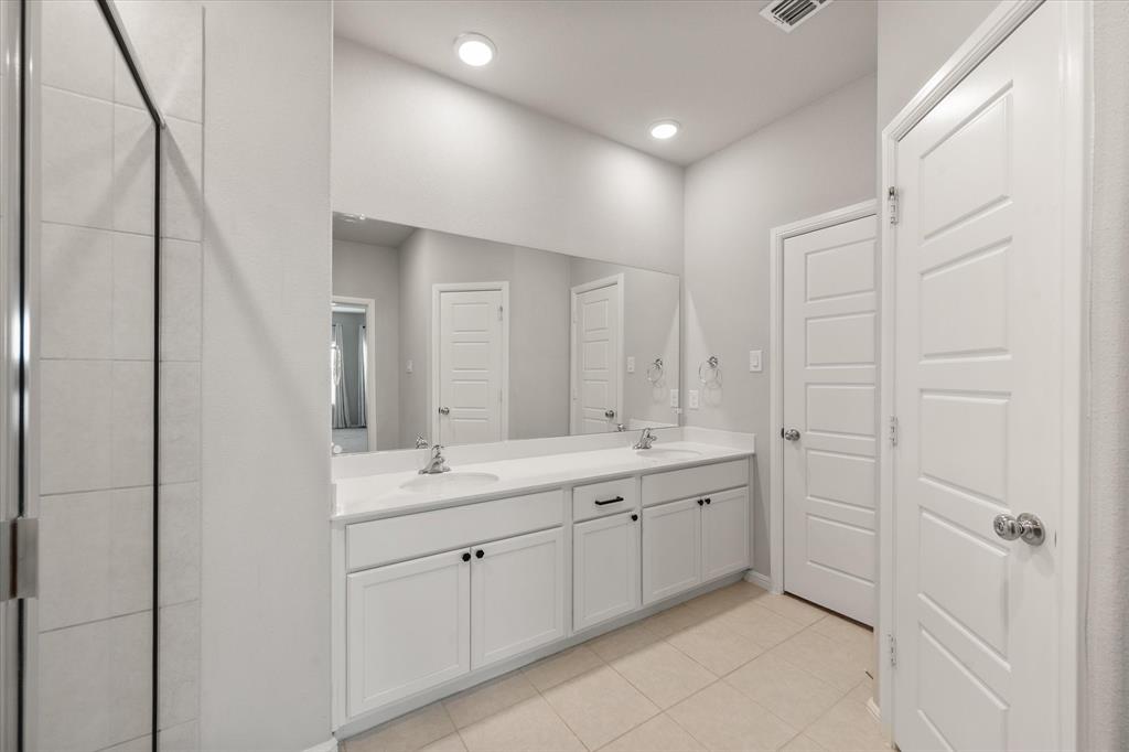 6910 Prairieside Trail Venus, TX 76084 - Photo 20 of 40 The bathroom features a double vanity with white cabinetry, light-colored countertops, and two integrated sinks