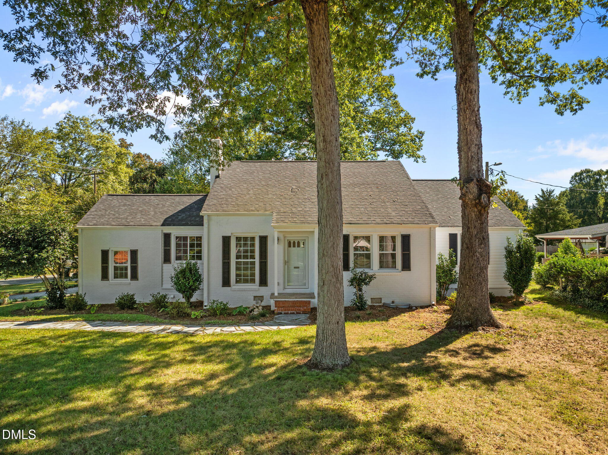 a front view of house with yard and trees around
