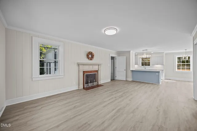 a view of a livingroom with wooden floor and a fireplace