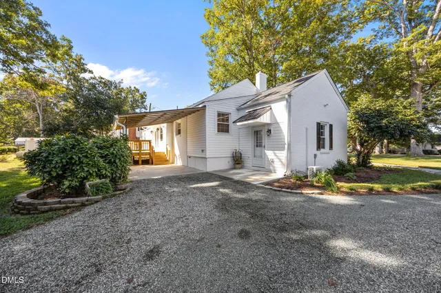 a view of a house with a yard and large tree
