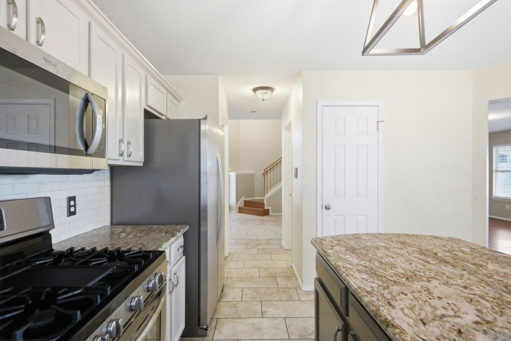 3201 Mocha Trail Austin, TX 78728 - Photo 13 of 26 a kitchen with stainless steel appliances granite countertop a stove and a refrigerator