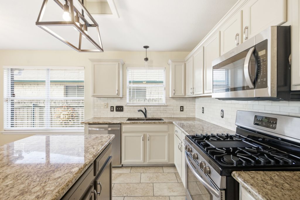 3201 Mocha Trail Austin, TX 78728 - Photo 14 of 26 a kitchen with stainless steel appliances granite countertop a sink stove and cabinets