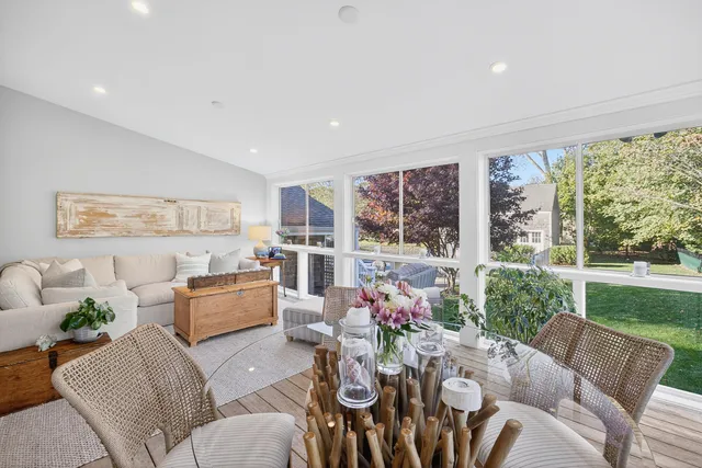 a bedroom with a large bed a table and windows