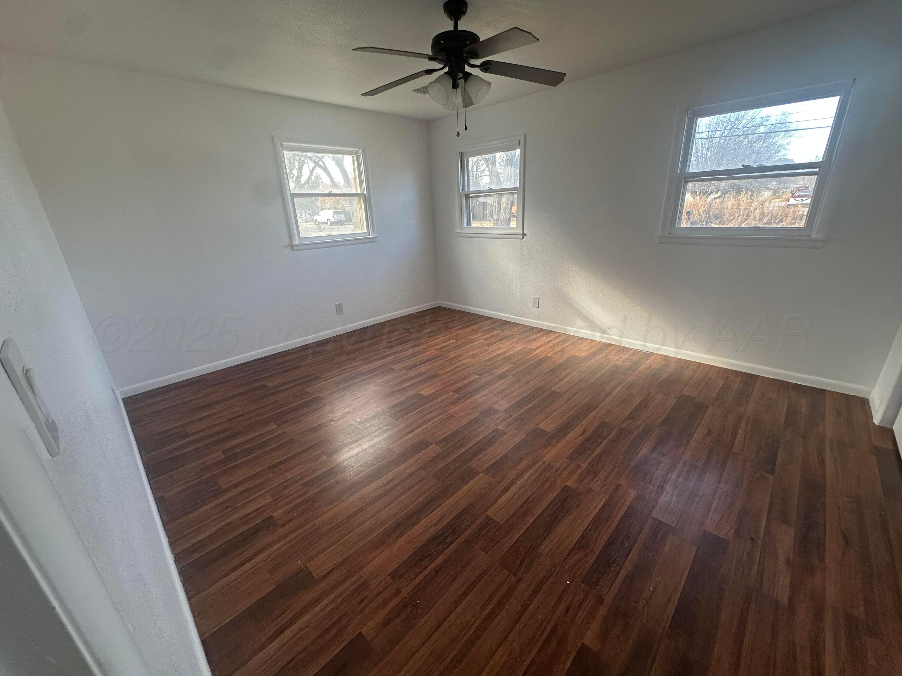 4854 Morning Drive Amarillo, TX 79108 - Photo 13 of 22 a view of an empty room with wooden floor and a window