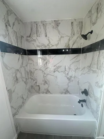 a bathroom with a bathtub and shower