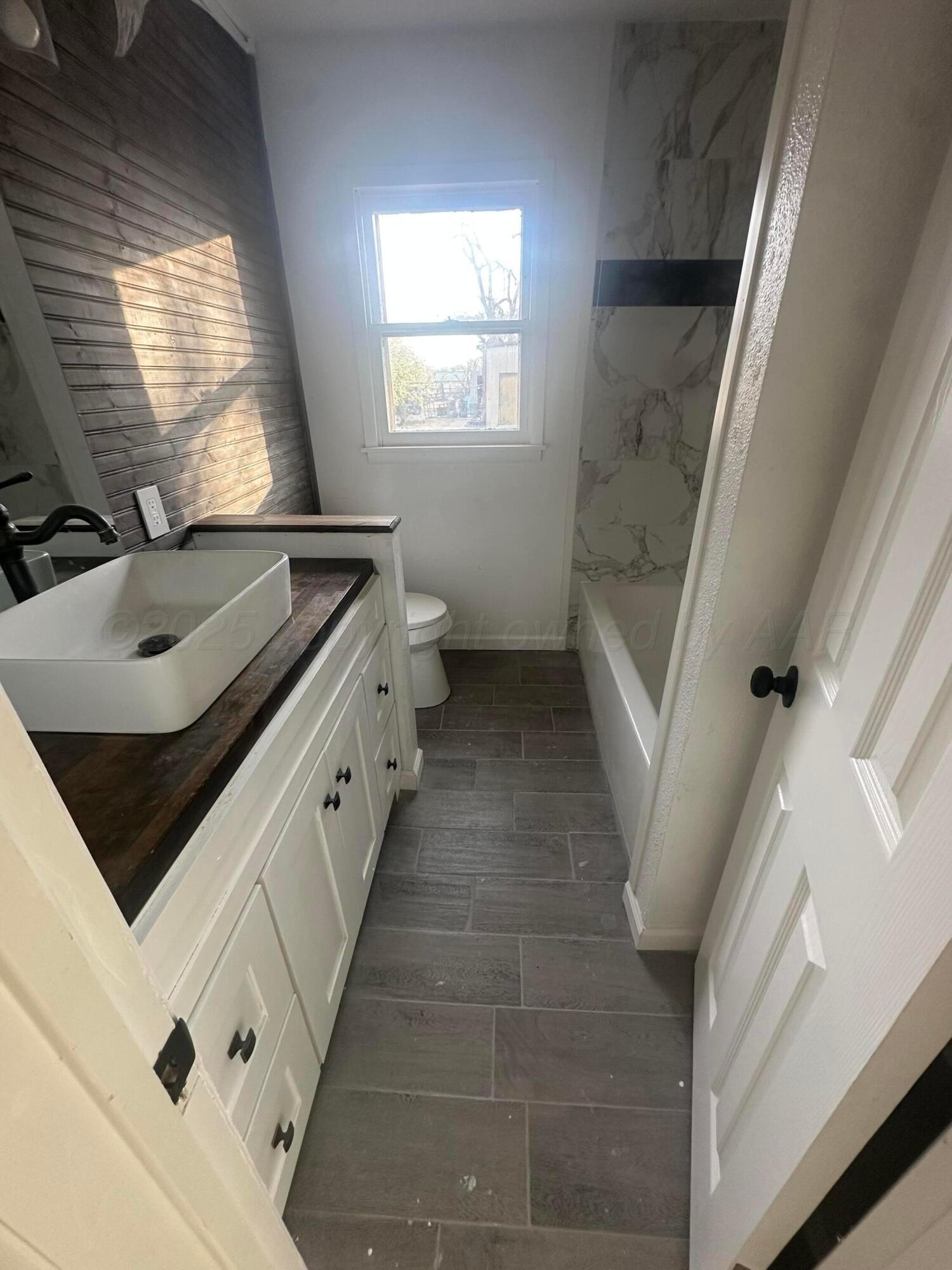 4854 Morning Drive Amarillo, TX 79108 - Photo 4 of 22 a bathroom with a granite countertop sink a toilet and vanity