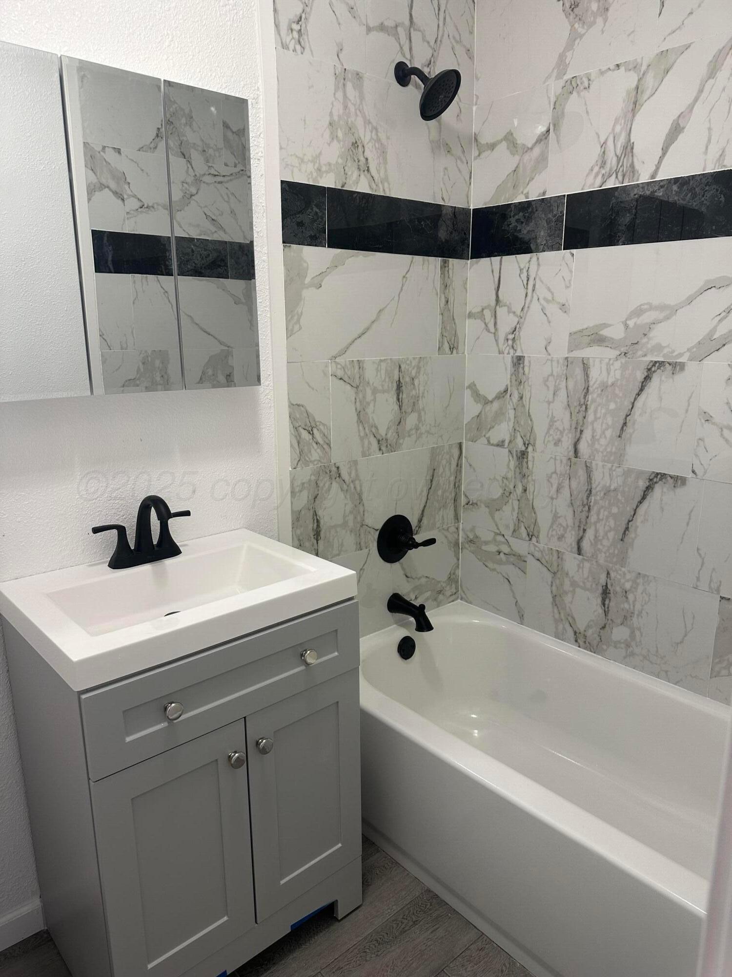 4854 Morning Drive Amarillo, TX 79108 - Photo 5 of 22 a bathroom with a sink and mirror with bathtub