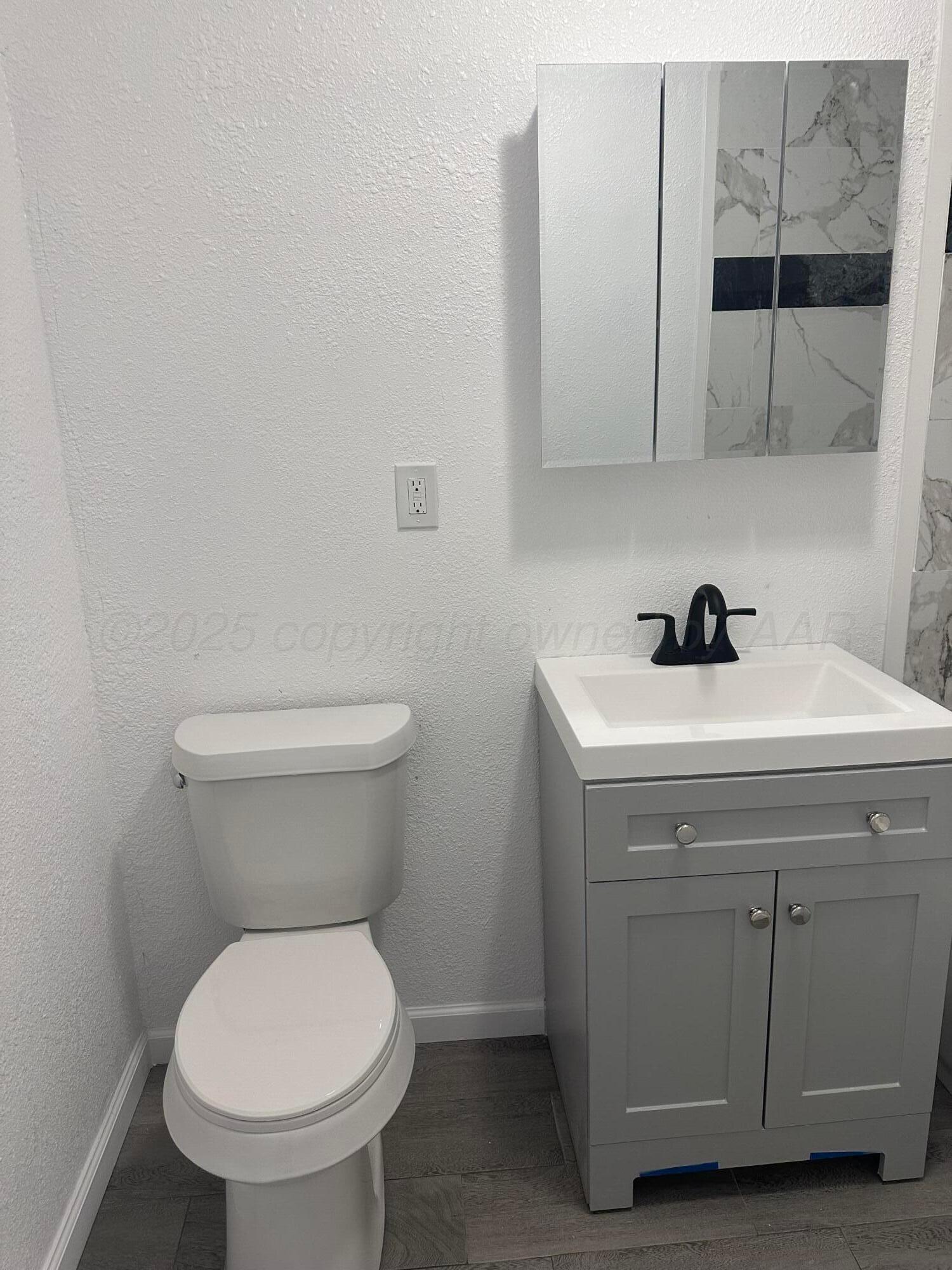 4854 Morning Drive Amarillo, TX 79108 - Photo 6 of 22 a bathroom with a sink a toilet and a mirror
