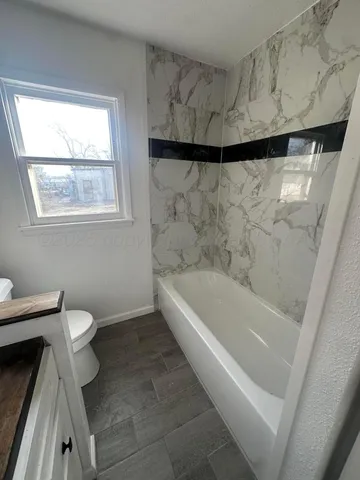 a bathroom with a toilet and a bathtub