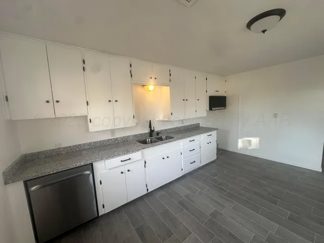 a kitchen with granite countertop white cabinets white appliances and granite counter tops