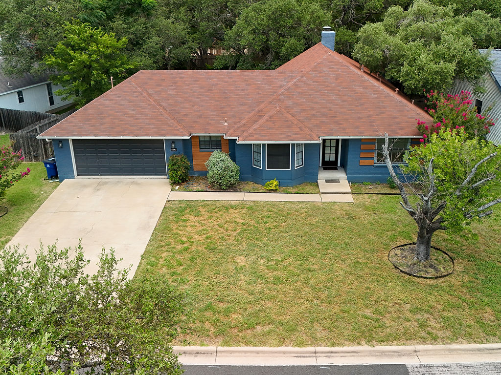 5842 Secrest Drive Austin, TX 78759 - Photo 2 of 40 A welcoming facade, blending traditional architecture with modern blue siding and lush, mature landscaping.