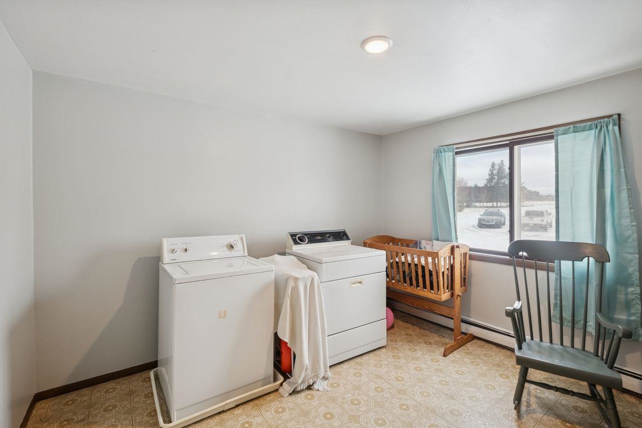60609 Argo Road Mason, WI 54856 - Photo 16 of 29 Laundry area featuring washing machine and dryer, a baseboard radiator, and light flooring