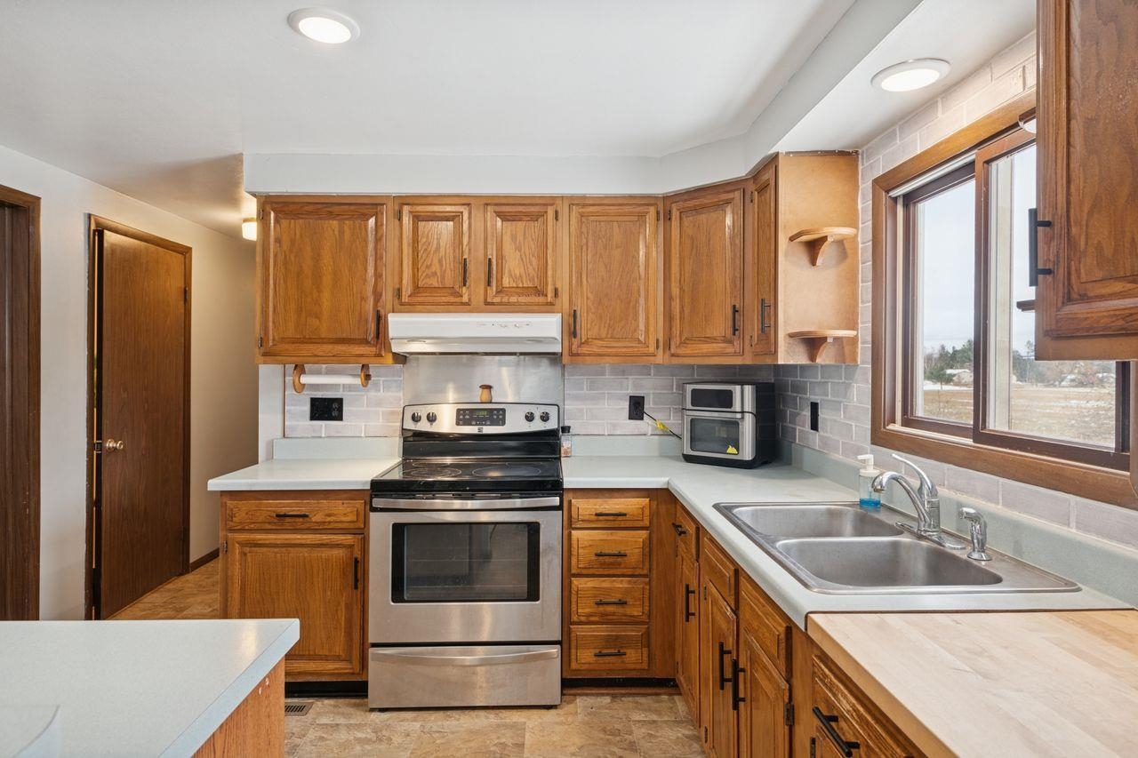 60609 Argo Road Mason, WI 54856 - Photo 9 of 29 Kitchen featuring electric range, tasteful backsplash, light countertops, and recessed lighting