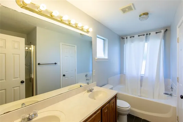 a bathroom with a granite countertop sink toilet and shower