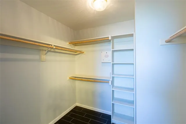 a view of walk in closet with empty racks