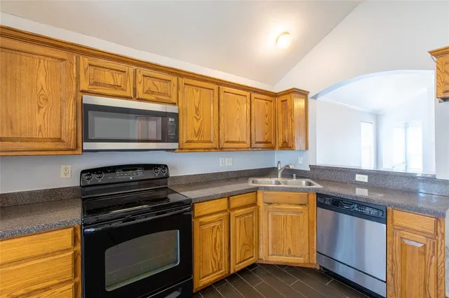 a kitchen with granite countertop a stove sink and microwave