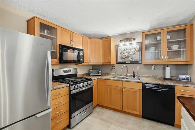 a kitchen with stainless steel appliances granite countertop a sink stove and cabinets