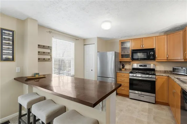 a kitchen with stainless steel appliances granite countertop a sink and a wooden cabinets