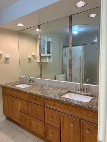 a bathroom with a granite countertop sink double and mirror