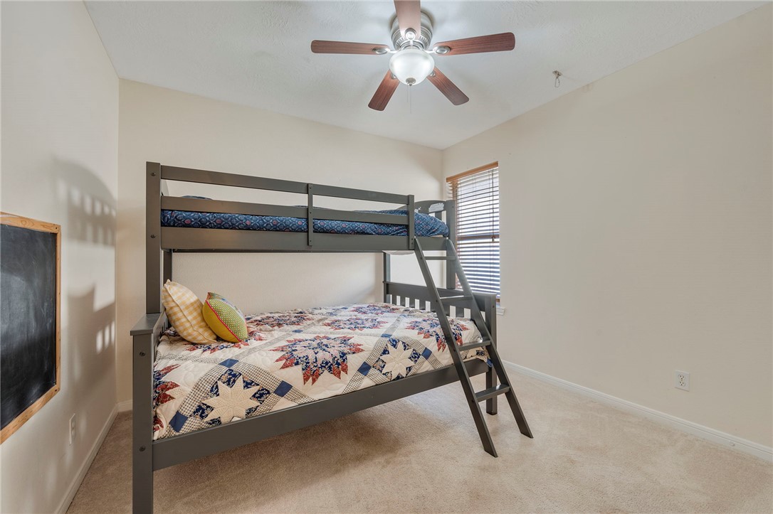 501 Riggs Street Brenham, TX 77833 - Photo 15 of 22 a bedroom with a bed and a chandelier fan