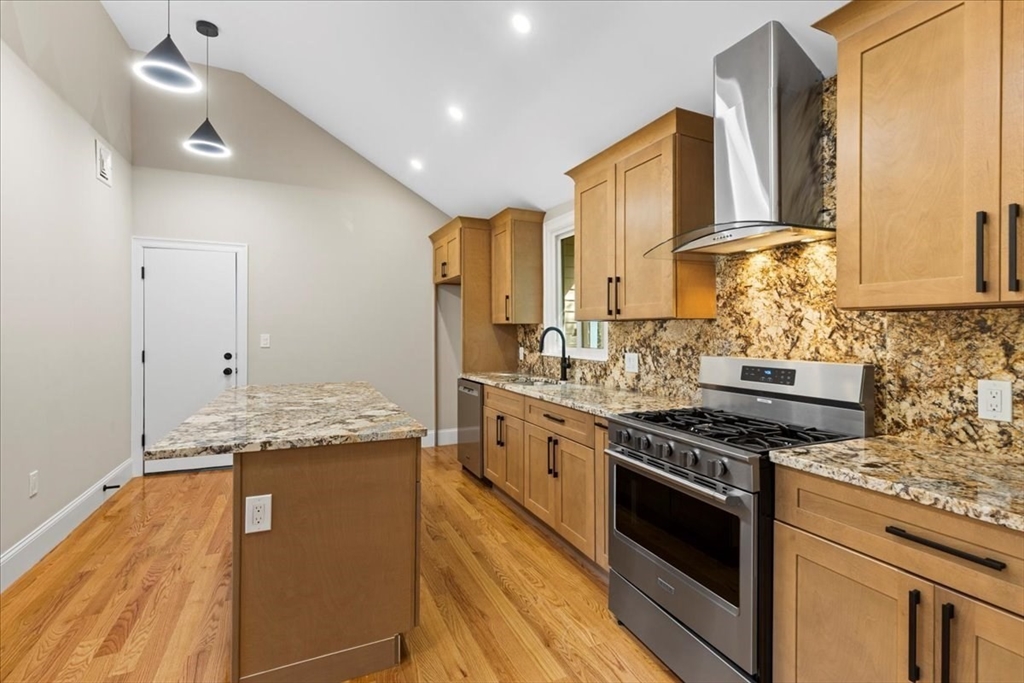 a kitchen with stainless steel appliances granite countertop a stove sink and cabinets