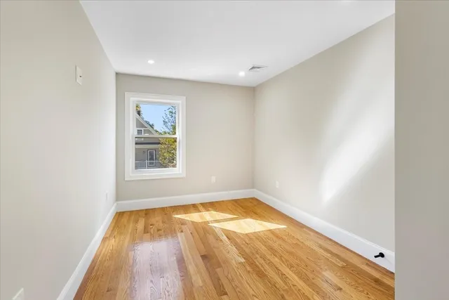 a view of a room with wooden floor and window