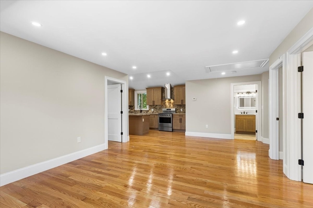 31 Woodale Avenue, Unit 3 Boston, MA 02126 - Photo 4 of 18 a view of a kitchen with kitchen island granite countertop a refrigerator and a sink
