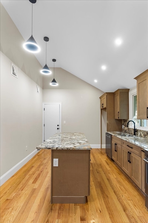 31 Woodale Avenue, Unit 3 Boston, MA 02126 - Photo 7 of 18 a large kitchen with kitchen island a sink stainless steel appliances and a chandelier