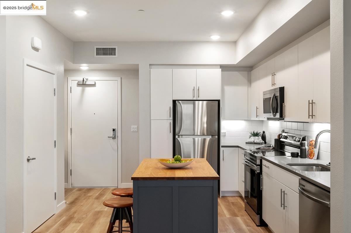 260 Brooklyn Basin Way, Unit 540 Oakland, CA 94606 - Photo 11 of 43 a kitchen with stainless steel appliances a refrigerator stove microwave and sink