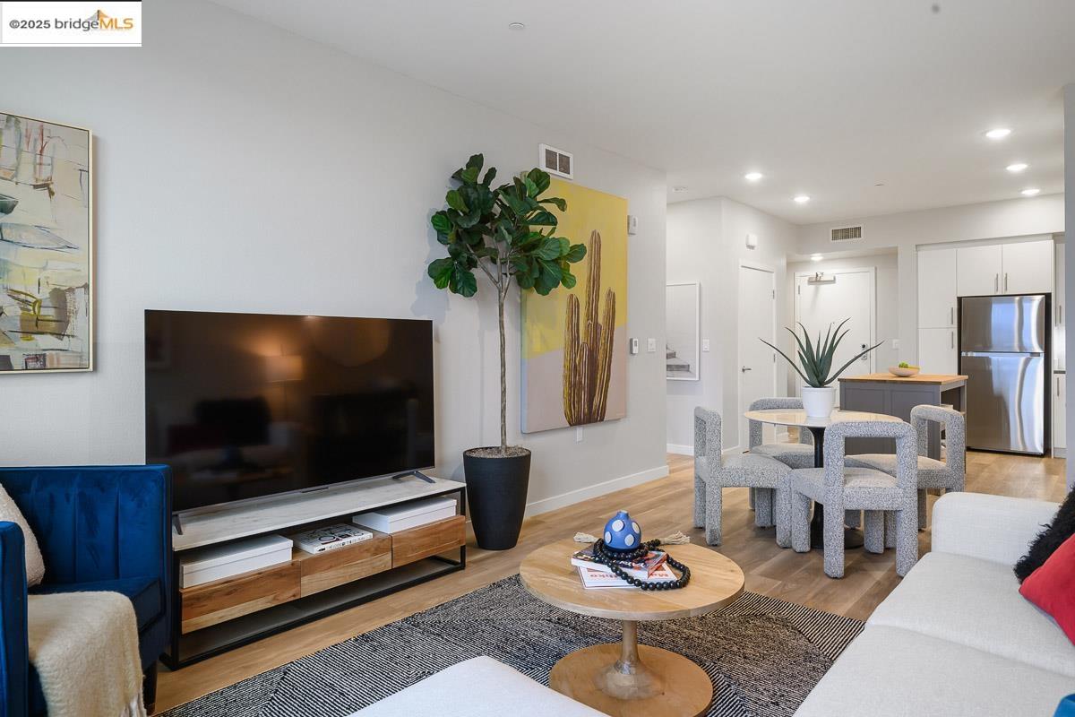 260 Brooklyn Basin Way, Unit 540 Oakland, CA 94606 - Photo 6 of 43 a living room with furniture and a flat screen tv