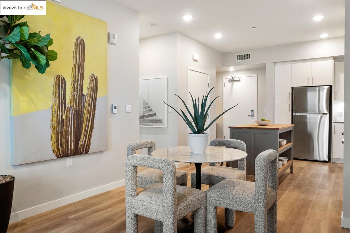 260 Brooklyn Basin Way, Unit 540 Oakland, CA 94606 - Photo 10 of 43 a dining room with furniture and a potted plant