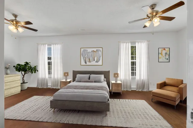 a bedroom with a bed couches and window