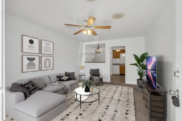 a living room with furniture a chandelier and a window