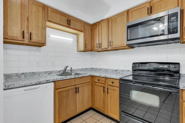 a kitchen with granite countertop cabinets stainless steel appliances and a sink