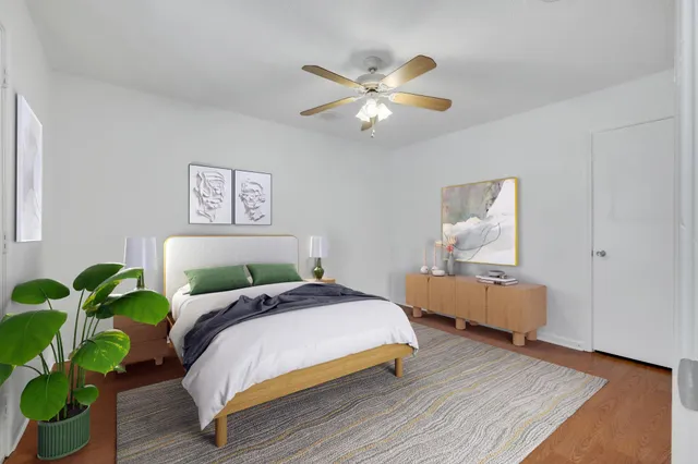 a bedroom with a bed lamp and a potted plant