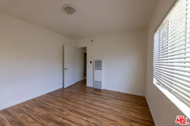 a view of a big room with wooden floor and windows