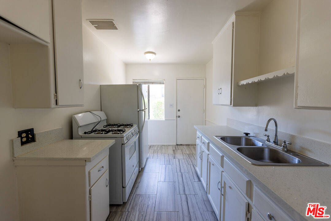 4119 Marlton Avenue, Unit 1 Los Angeles, CA 90008 - Photo 7 of 13 a kitchen with stainless steel appliances a sink stove and refrigerator