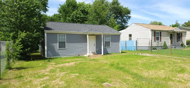 a view of a house with yard and tree s