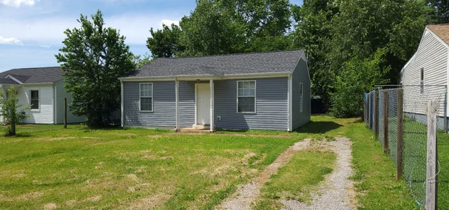 a backyard of a house with large garden and plants