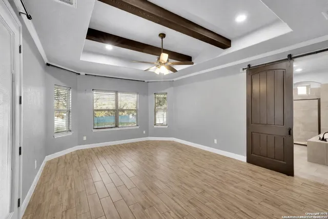 a spacious bathroom with a tub shower and mirror