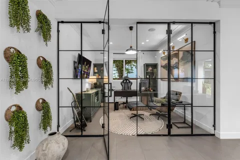 a room with lots of white furniture and glass door